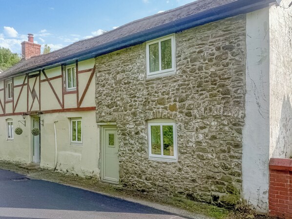 A traditional stone house with a gabled roof, multiple windows, and a chimney. - 3 bedroom accommodation in Llanfair Caereinion (Llanfair Caereinion)