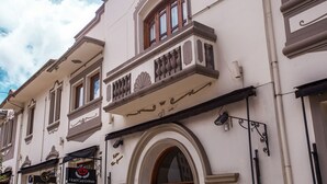 A building with a balcony, arched windows, and a sign for 'Hotel Gampel'. - Hotel Gambrinus (Poços de Caldas)