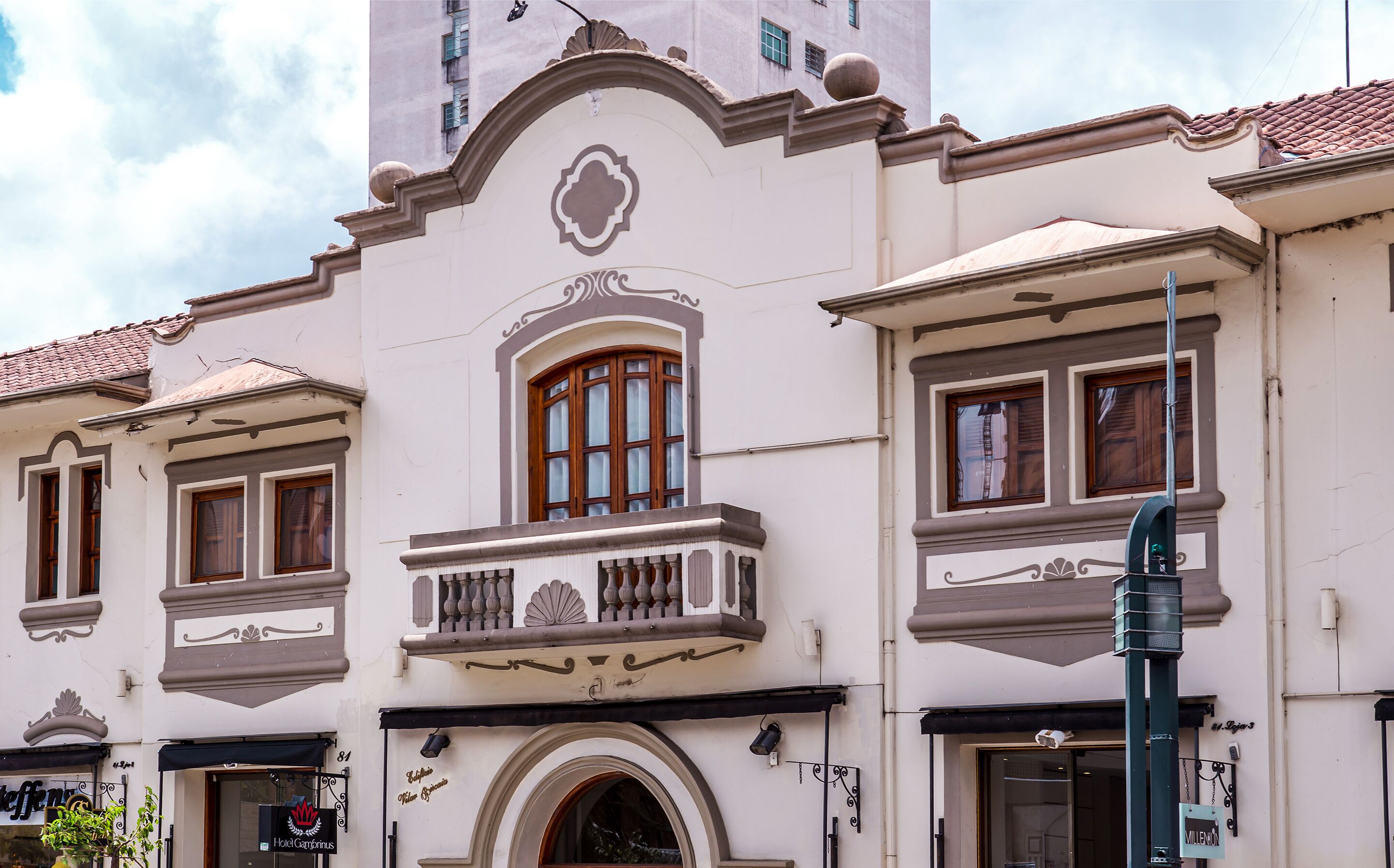A historic building with a central balcony, arched windows, and a decorative facade.