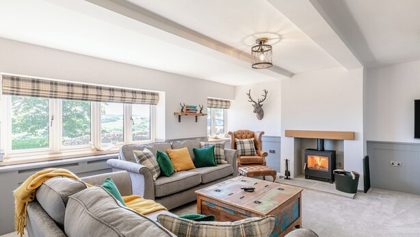 Una sala de estar con sofá, sillón y chimenea.