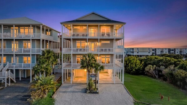 A multi-story hotel with balconies, a covered entrance, and a landscaped driveway.