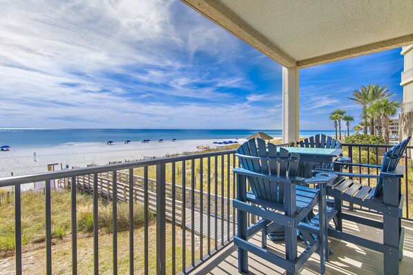 Un balcon avec vue sur la plage et l’océan.