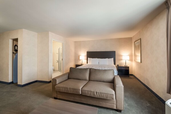 SureStay Plus SeaTac standard king room with modern furnishings, flat-screen TV, and sitting area