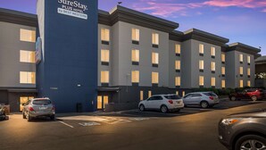 A multi-story hotel with a prominent sign for SureStay Plus Hotel by Best Western.