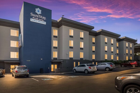 Ein mehrstöckiges Hotel mit einem gut sichtbaren Schild für SureStay Plus Hotel by Best Western.