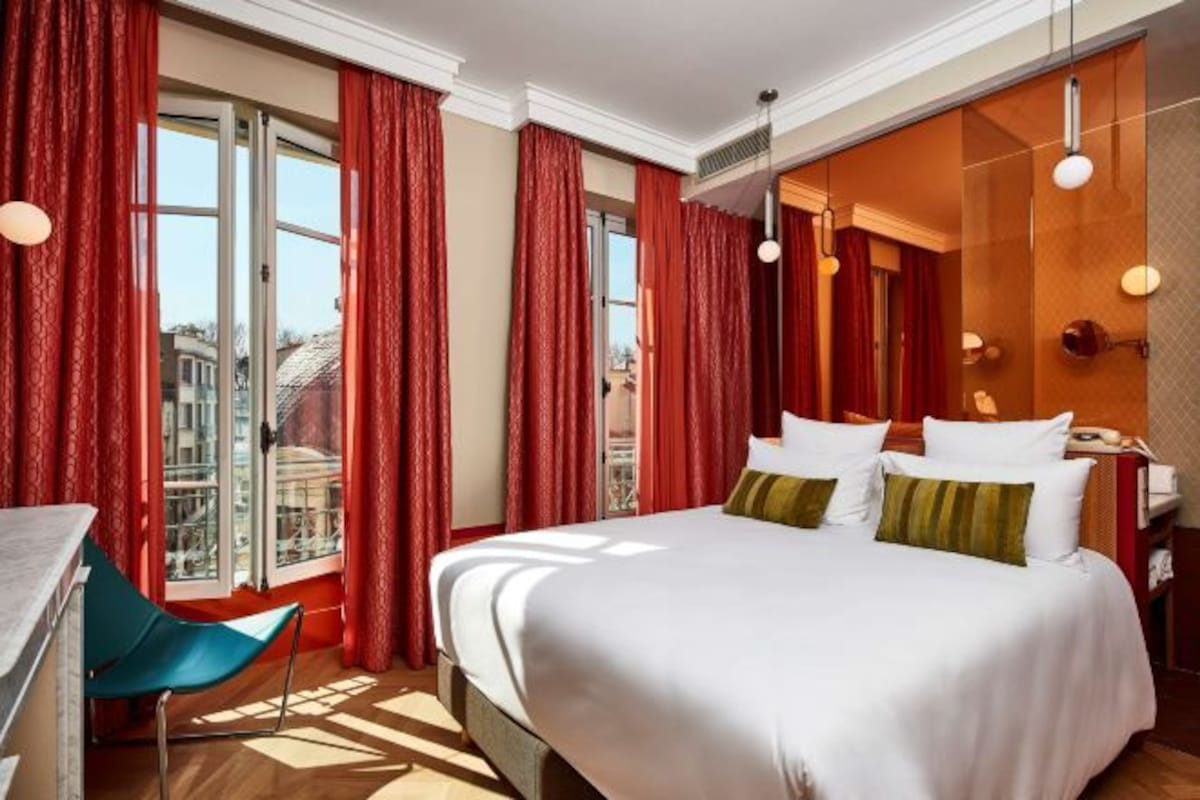A hotel room with a bed, a desk, and a chair.