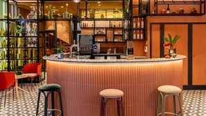 A bar area with a counter, stools, and shelves with bottles. - Hotel De Cambis (Avignon)