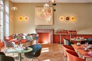 Un comedor moderno con mesas redondas, sillas y una chimenea.