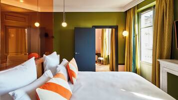 A hotel room with a bed, a desk, and a view of the city.