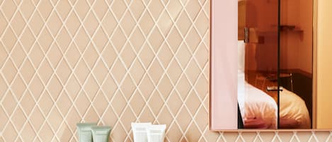 Un baño con pared estampada, un espejo y artículos de aseo sobre una encimera.