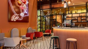 A bar area with a neon art installation, seating, and a bar counter with various bottles. - Hotel De Cambis (Avignon)