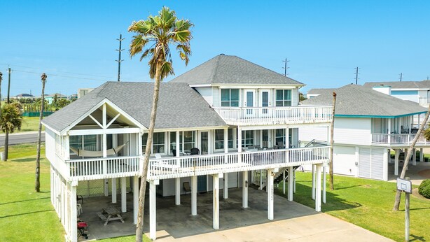 A two-story house with a balcony, a covered porch, and a small deck area. - 2nd Row Gulf View Home w/ 2 Decks, Board Games, 3 Kings+Bunk all w/Deck Access (Galveston)
