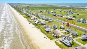 An aerial view of a coastal residential area with houses, a beach, and a road. - 2nd Row Gulf View Home w/ 2 Decks, Board Games, 3 Kings+Bunk all w/Deck Access (Galveston)