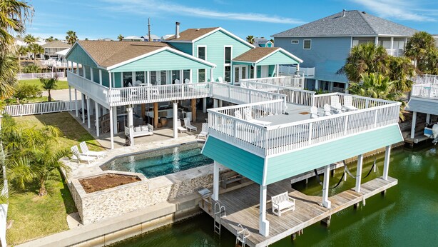 A waterfront property with multiple decks, a swimming pool, and a dock. - Private Canal Home w/ 2 Living Areas, Easy Bay Access & POOL (Galveston)