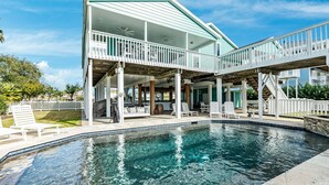 A two-story house with a swimming pool, outdoor seating, and a covered patio area. - Private Canal Home w/ 2 Living Areas, Easy Bay Access & POOL (Galveston)