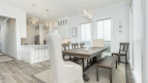 A modern kitchen with white cabinets, a central island, and pendant lighting. - Beachside Home w/ POOL, 2 Covered Decks - 2 Blocks to Beach, 9 mi from Downtown (Galveston)