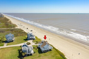 A coastal property with multiple houses, a beach, and a clear view of the ocean.