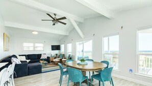 A spacious living area with a dining table surrounded by chairs, a sofa, and a ceiling fan. - Updated Pet Friendly Beachfront Home w/ Open Plan, Equipped Kitchen, Free Wifi (Galveston)