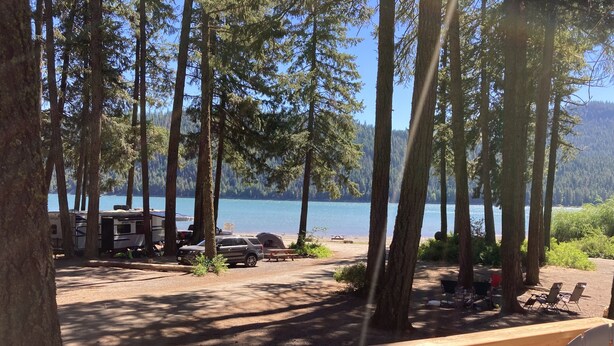 Un terrain de camping avec des emplacements pour camping-cars, une table de pique-nique et une vue sur le lac.