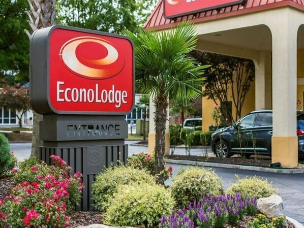 An EconoLodge entrance sign with a red and white logo, surrounded by landscaped gardens and a parking area. - Econo Lodge Stockbridge (Stockbridge)