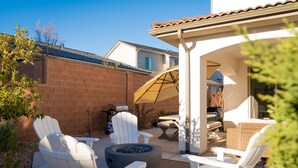 A patio with white Adirondack chairs, a black fire pit, and a table with a grill. - LeBlanc 5 Bedroom!  5 Bath! Firepit! Dog Friendly! (Washington)