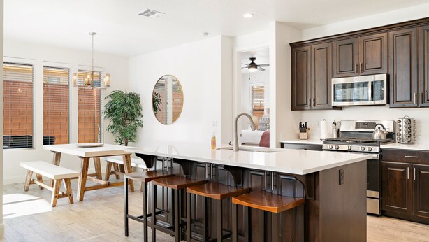 A modern kitchen with a central island, bar stools, wooden benches, and dark cabinetry. - LeBlanc 5 Bedroom!  5 Bath! Firepit! Dog Friendly! (Washington)