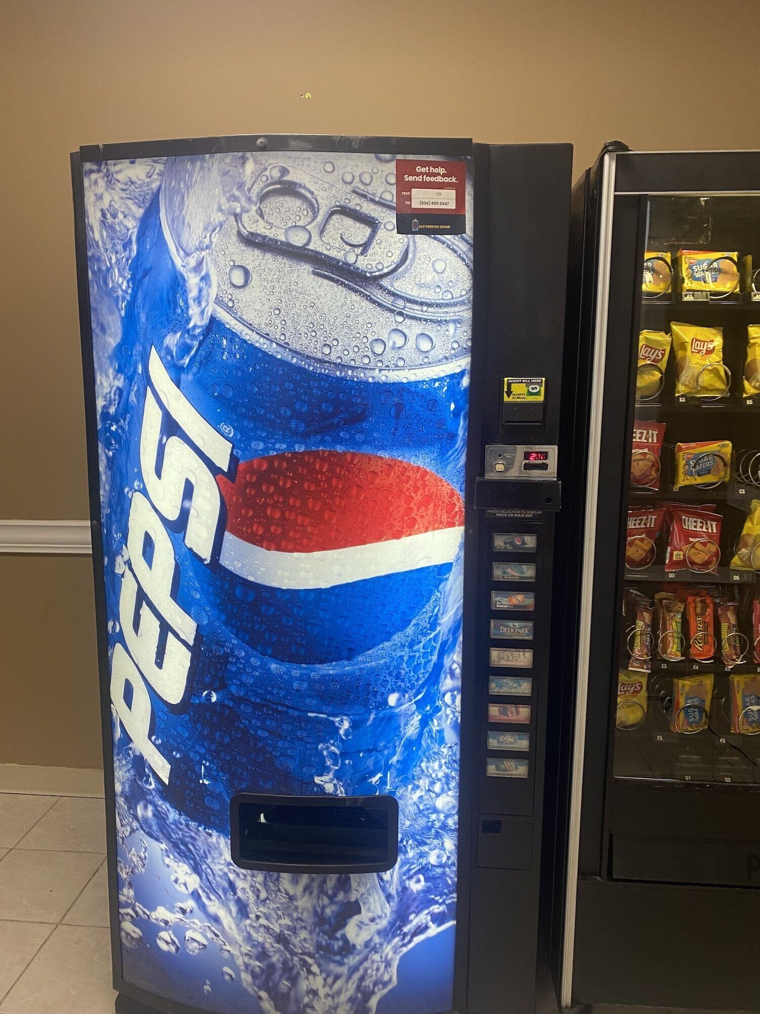 Un distributeur automatique affichant une publicité pour Pepsi et proposant un assortiment de collations.