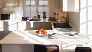 Une cuisine moderne dotée d’un îlot central, d’un évier et d’une fenêtre située au-dessus de l’évier.