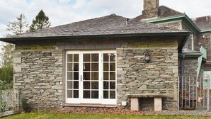 Une maison en pierre avec une grande fenêtre et une cheminée.