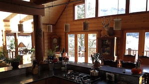 Una cocina amplia con armarios de madera, una isla central y ventanas grandes.