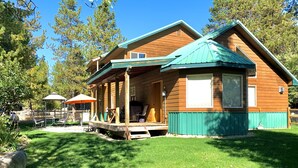 A wooden cabin with a porch, a covered outdoor seating area, and a grill. - The Smitty Place- family friendly, near downtown, great parking! (McCall)