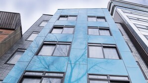 A building with a modern facade, large windows, and the name "PEACHTREE" on the lower part. - Peachtree Suites (Jersey City)