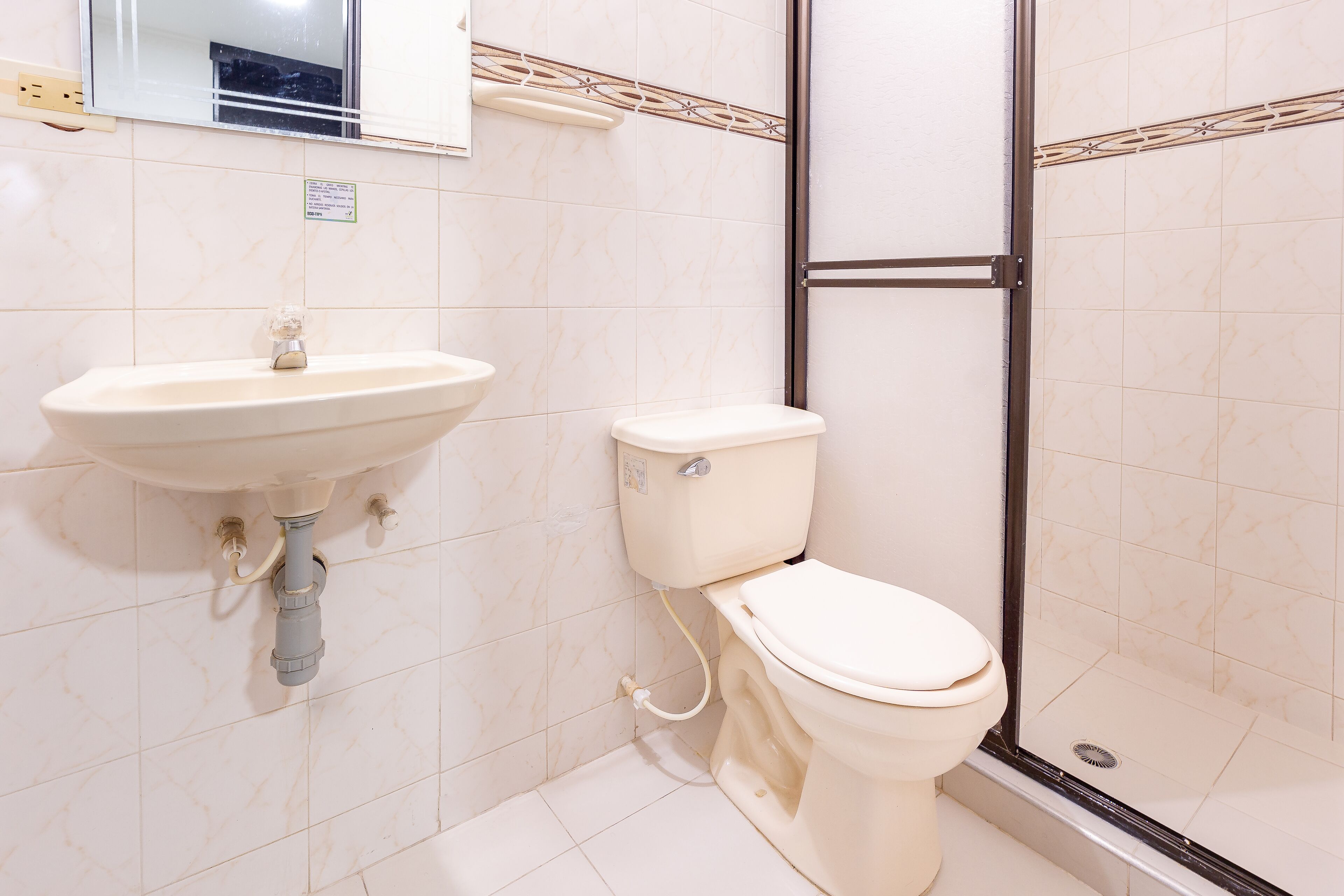 A bathroom with a sink, toilet, and shower area.