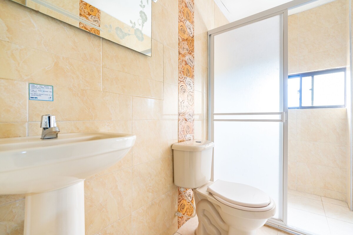 A bathroom with a sink, toilet, and a shower area.
