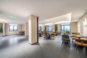 A spacious conference room with multiple tables and chairs, large windows, and a modern design. - Sijiqing Teng Hotel (Ningbo Jiangshan Wanda Plaza Branch) (Ningbo)