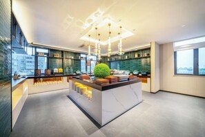 A modern kitchen with a central island, pendant lighting, and large windows.