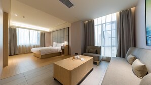 Une chambre d’hôtel moderne équipée d’un lit, d’un canapé, d’une table basse et d’un bureau.
