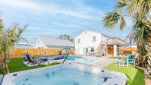 A backyard with a hot tub, a swimming pool, and a covered patio area. - Atlantic View Heated Pool/Spa/Firepit/Beach/Golf/Sleeps 12 (St. Augustine)