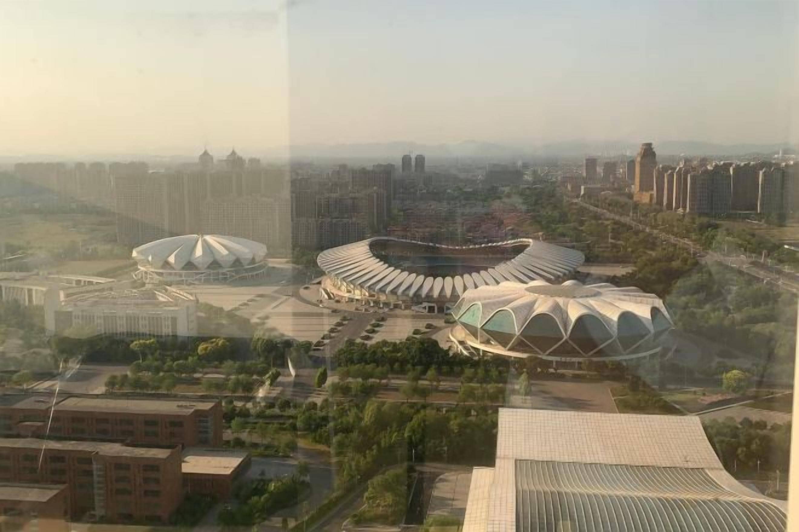 A large stadium with a distinctive dome structure, surrounded by urban buildings and greenery.