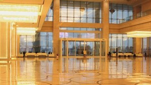 A spacious lobby with a polished floor, large windows, and a central revolving door. - Jiujiang Hotel (Qian'an)