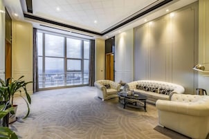 Un salón amplio con un gran ventanal, un conjunto de sofás y una mesa de centro.