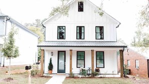 A two-story white house with a front porch, a black door, and a number '200' on the door. - Premium 3BR Home by MHM Luxury Properties (Athens)