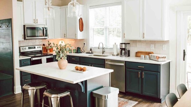 A modern kitchen with white cabinetry, stainless steel appliances, and a central island with stools. - Premium 3BR Home by MHM Luxury Properties (Athens)