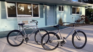 Una casa de dos pisos con un porche y una bicicleta estacionada al frente.