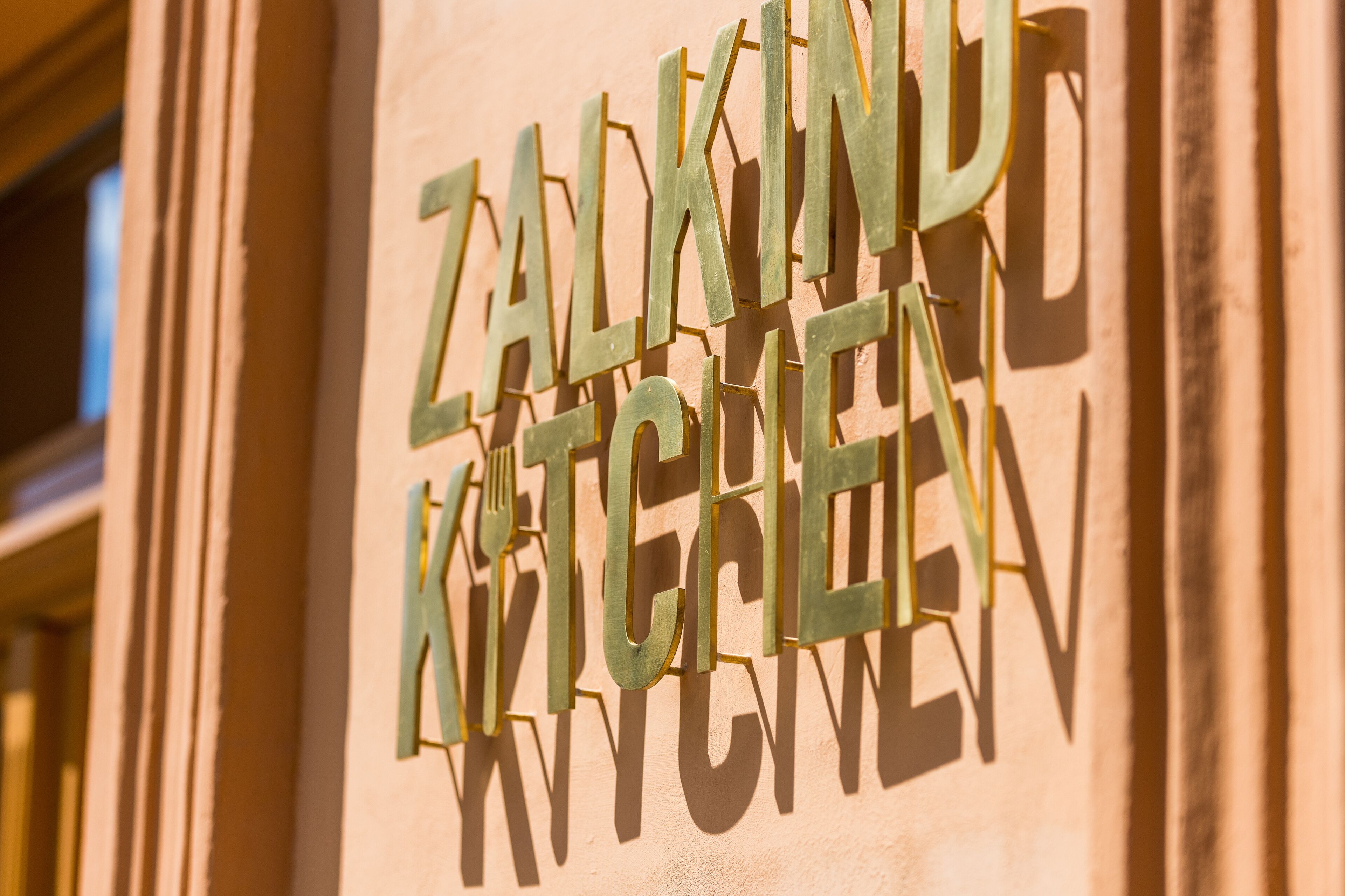 Een bord met de tekst 'ZALKIND KITCHEN' op een gevel.