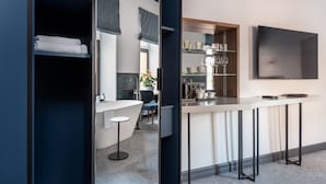 A modern kitchen with a bar area, built-in shelves, and a large flat-screen TV. - Zalkind Hotel Rooms&Kitchen (Minsk)