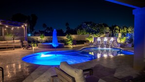 An outdoor swimming pool area with a hot tub, seating, and ambient lighting. - Desert Pickle-ball Paradise in Scottsdale (Scottsdale)
