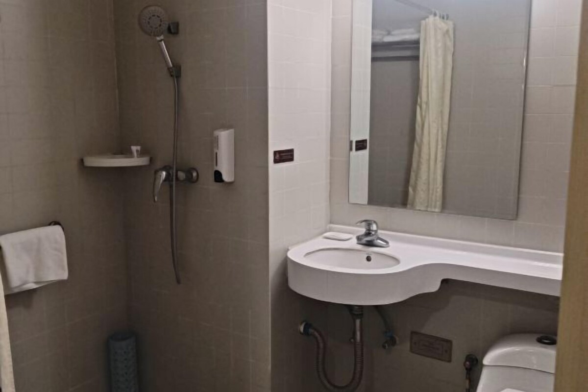 A bathroom with a shower, sink, and toilet.