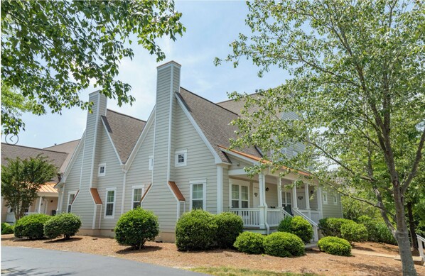 Stunning two-story house with a central chimney and gabled dormer windows.