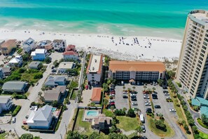 A coastal hotel with a beach view, parking, and a pool area. - Windancer 307. Gulf Front Condo, Free Beach Service, Heated Pool, Grill. (Miramar Beach)